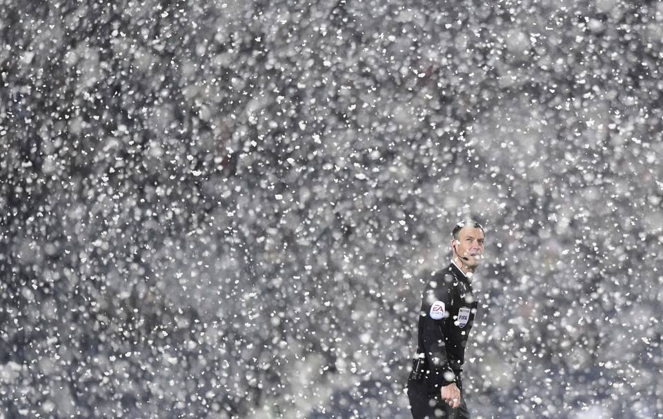 L&#39;arbitro Mark Clattenburg, 39 anni, cerca di orientarsi sotto la neve. Reuters